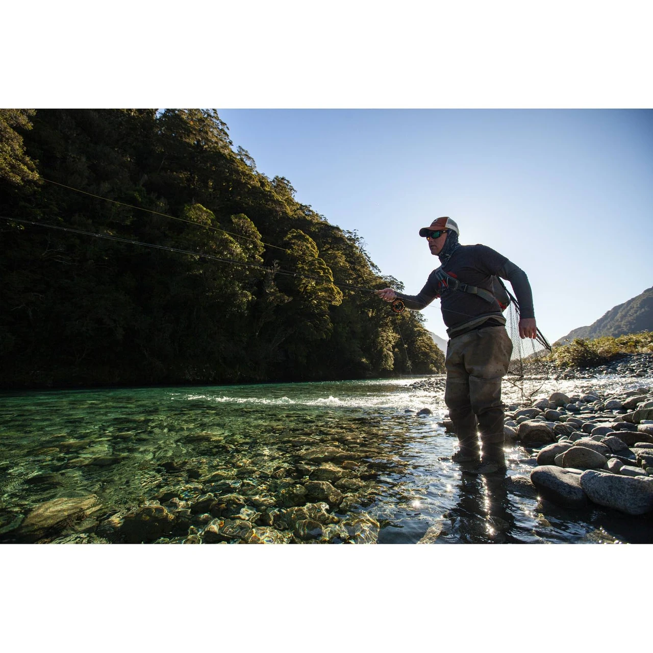 Angler fishing a Scott Centric fly rod on a clear river