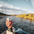 Angler fighting a fish on a Douglas SKY G from a drift boat
