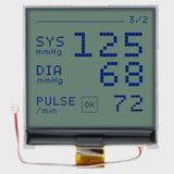 Front view of a 128x128 graphic COG LCD showing diagnostic information in dark text on an unlit STN+ gray screen with attached FFC and backlight power cables.
