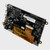 Angled view of a black HDMI module PCB attached to the back of a 5-inch TFT LCD with the right side angled toward the viewer to highlight its profile and mounting holes.