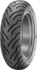 A high-resolution studio product photograph of the Dunlop American Elite rear touring cruiser tire in 240/40R18 79V sizing (Part #45131730), set against a seamless white background. Positioned standing vertically at a three-quarter perspective, the tire highlights its ultra-wide radial profile designed specifically for heavy V-Twin cruisers and custom touring motorcycles. The tread pattern features deep, sweeping lateral grooves for efficient wet-weather water dispersion and extended tread life, complemented by Multi-Tread (MT) compound technology for increased straight-line mileage and cornering grip, finished with crisp, embossed "AMERICAN ELITE" sidewall branding along its matte black rubber casing.