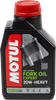 A high-resolution studio product photograph of a bottle of Motul Fork Oil Expert Heavy in SAE 20W viscosity, set against a clean white background. Standing upright at a front-facing angle, the compact white plastic container features a cylindrical base and a bright red twist-off cap. The distinct front label displays a bold orange, black, and red graphic featuring a motorcycle front fork diagram alongside the white "MOTUL" logo on a red base banner, paired with crisp white and yellow "FORK OIL EXPERT", "HEAVY 20W", and "TECHNOSYNTHESE®" callouts.