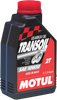 A high-resolution studio product photograph of a 1-liter container of Motul Transoil Transmission Fluid in 10W-30 viscosity, set against a clean white background. Standing upright at a front-facing angle, the sleek dark gray plastic bottle features a textured ergonomic grip and a red twist-off cap. The dynamic front label displays the bold white "MOTUL" logo vertically alongside a vibrant blue "TRANSOIL", "10W-30", "TRANSMISSION FLUID" callout, and a detailed graphic of motorcycle gearbox gears and shaft components, specially formulated for gearboxes with integrated wet clutches requiring separate transmission oil.