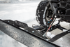 Close-up of an Open Trail plow blade and push tube in front of a UTV tire