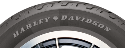 Three-quarter angle studio view of the Dunlop D401 130/90B16 rear blackwall cruiser tire displaying its deep computer-optimized center grooves against a plain white backdrop.