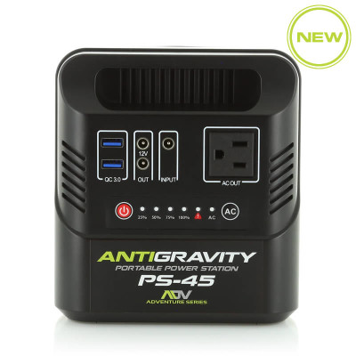 Antigravity PS-45 ultra-compact lithium portable power station with its rugged black chassis and integrated carrying handle, showing its front-facing AC outlet, dual Quick Charge USB ports, dual 12V DC ports, and the 4-stage blue LED power indicator panel, photographed on a clean white studio floor.