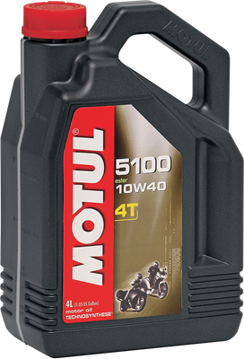 A high-resolution studio product photograph of a bulk 4-liter container of Motul 5100 4T Technosynthese synthetic blend engine oil in 10W-40 viscosity, set against a clean white background. Standing upright at a front-facing angle, the ergonomic black plastic jug features a integrated carrying handle, side grip ridges, and a red twist-off cap. The front label showcases the bold white "MOTUL" logo set vertically in a red banner alongside bright green "5100", "10W-40", "MA2", "TECHNOSYNTHESE ESTER", and "4T MOTOR OIL" callouts, accented by a dynamic green-and-black motorcycle racing graphic. Formulated with synthetic ester technology, it complies with JASO MA2 and API SP/SN standards to provide outstanding gear protection, thermal stability, smooth wet-clutch operation, and anti-wear defense across street, trail, and dual-sport four-stroke motorcycles.