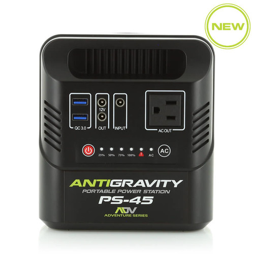 Antigravity PS-45 ultra-compact lithium portable power station with its rugged black chassis and integrated carrying handle, showing its front-facing AC outlet, dual Quick Charge USB ports, dual 12V DC ports, and the 4-stage blue LED power indicator panel, photographed on a clean white studio floor.