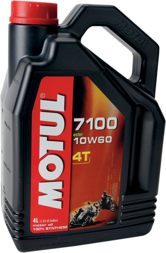 A high-resolution studio product photograph of a bulk 4-liter container of Motul 7100 4T 100% Synthetic engine oil in 10W-60 viscosity, set against a clean white background. Standing upright at a front-facing angle, the heavy-duty matte black plastic jug features an ergonomic integrated top handle, side grip ridges, and a red twist-off cap. The distinct front label displays a dark panel featuring a motorcycle silhouette graphic alongside bright orange and white "7100", "10W-60", "100% SYNTHETIC", "ESTER", and "4L" callouts above the white "MOTUL" logo set on a bold red banner.