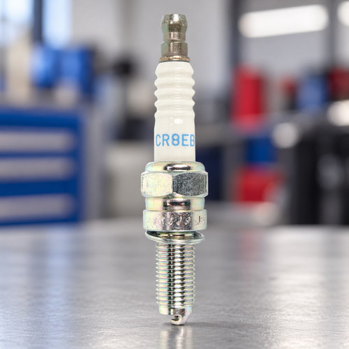 NGK CR8EB 7784 motorcycle spark plug displayed in a professional service workshop