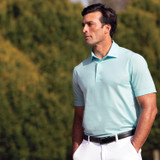 Lifestyle model wearing seafoam blue golf shirt info