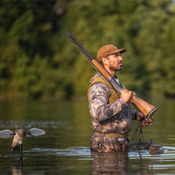 Wading waters in the Benelli Pump-Action shotgun with a dove flying away 