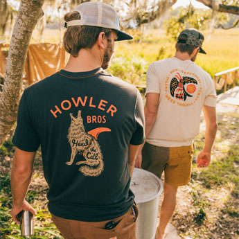 Two guys in Howler Bros T-Shirts getting ready for an outdoor feast