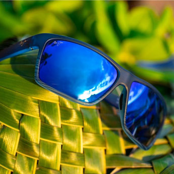 A pair of Maui Jim's sunglasses against a green background