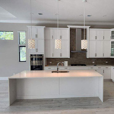 3 hanging pendant lights above a kitchen island