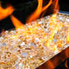 Medium shot of glowing gold tempered fire glass in a blazing fire pit