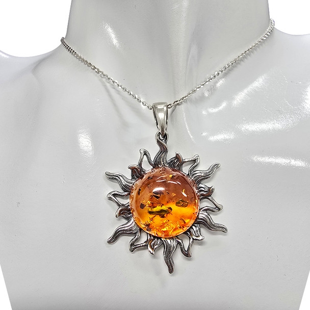 Amber Oxidized Sterling Silver Sun Pendant 19–20mm. A round-shaped cognac-colored genuine Baltic amber stone is set in oxidized .925 sterling silver. Elegant sun design.
