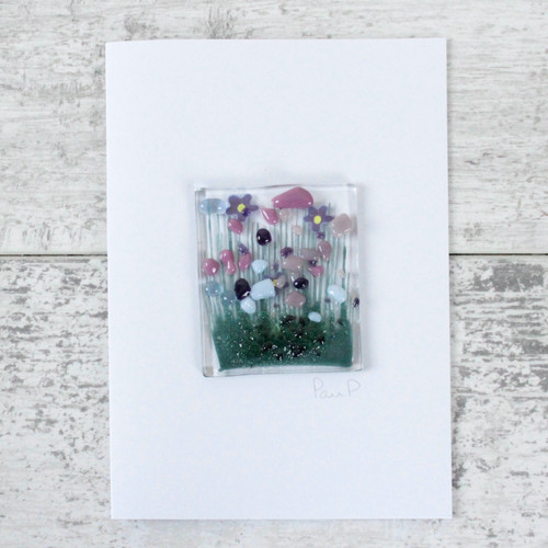 A square glass deco with an image of violets attached to a white greetings card