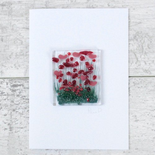 A square glass deco with and image of poppies, attached to a white greetings card.