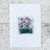 A square glass deco with an image of violets attached to a white greetings card
