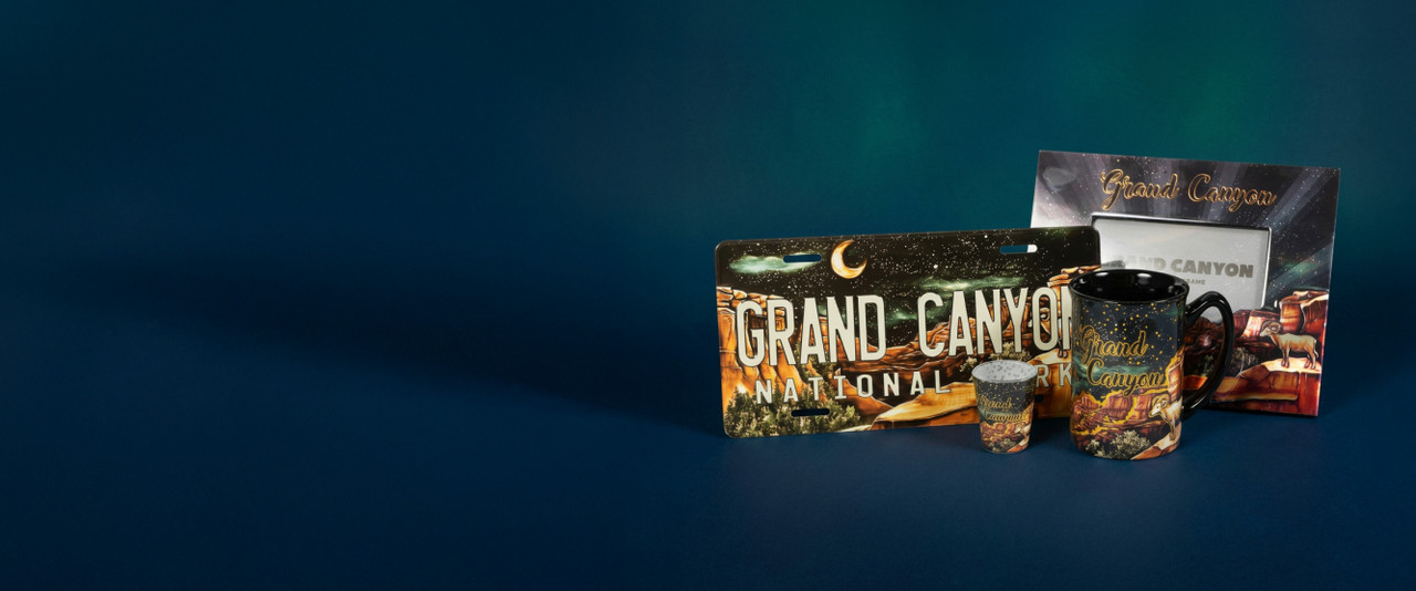 A license plate, shot glass, mugs, and frame with metallic stars and night sky at the Grand Canyon.