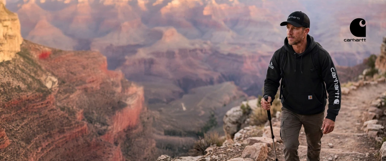 Man in black Carhartt hat and hoodie hiking in the Grand Canyon.