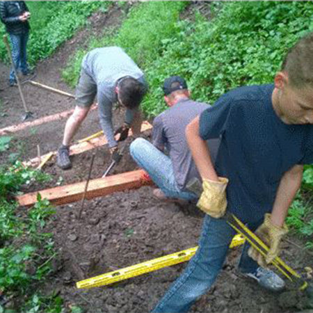 Two men and a young boy helping build steps