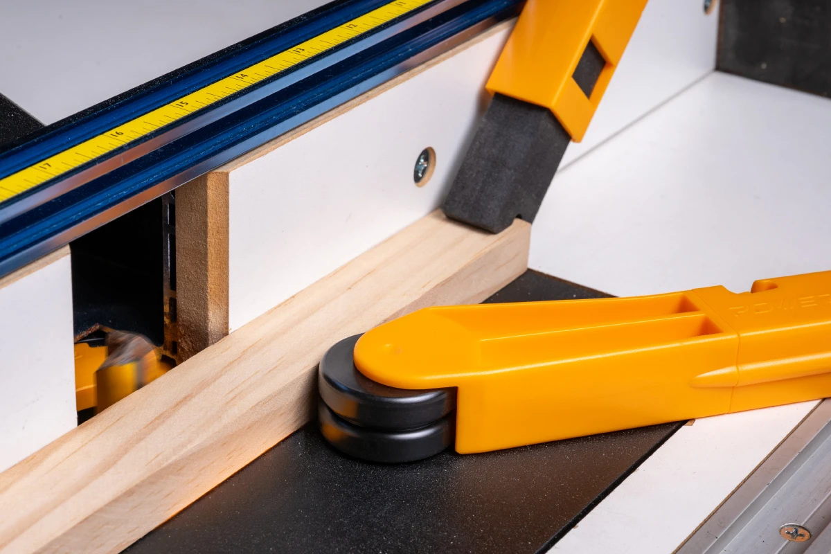 Roller guide applying side pressure to keep stock against a woodworking fence