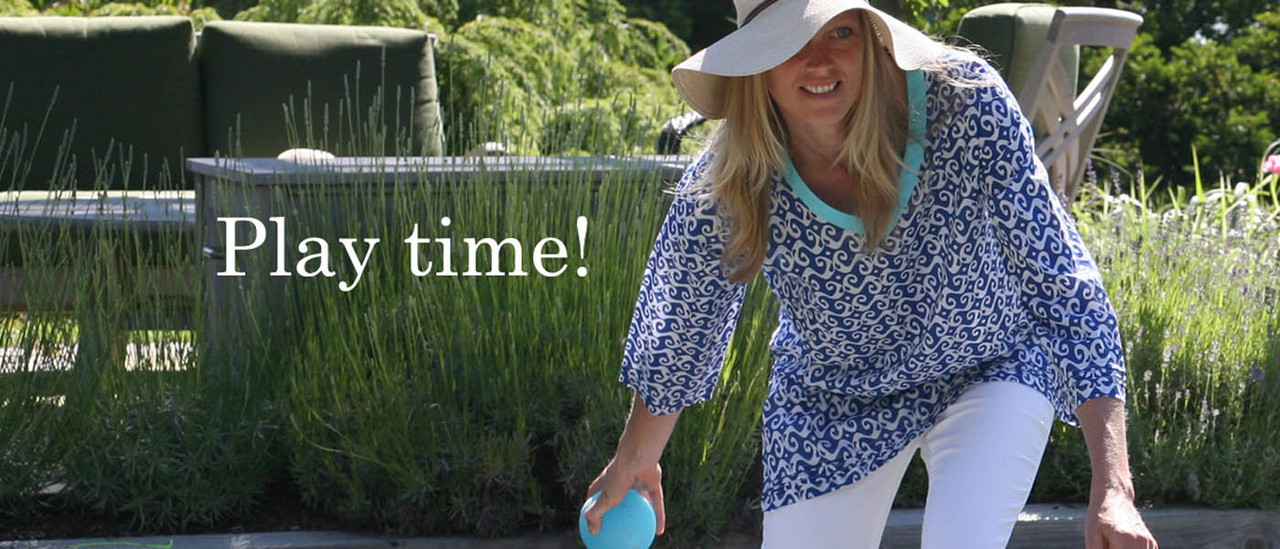 Woman wearing blue and white tunic playing bocce ball. Woman wearing blue and white tunic playing bocce ball.