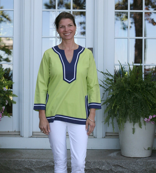 Woman wearing pullover lime green tunic with contrasting navy and white banding at neckline, cuffs and hem.



