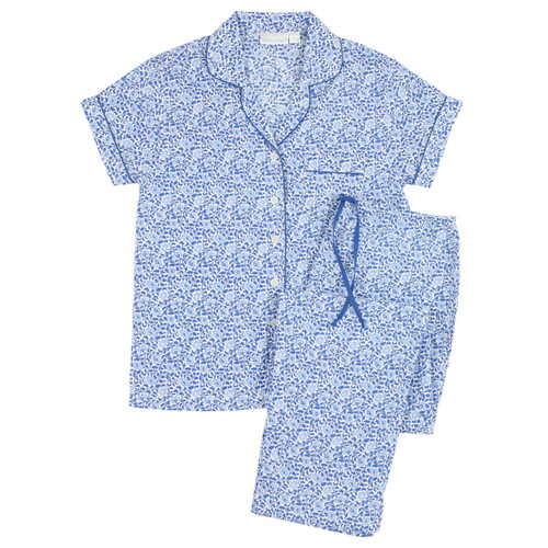 Women's cotton poplin button-down short sleeve long pant pajamas.  Printed with small, repeating blue and white floral pattern. Two-piece pajama set lying flat.