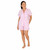 Woman standing wearing pink and white striped seersucker short sleeve pajamas with boxer shorts. Pajamas are trimmed with pink piping.