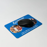 A black mouse positioned on a blue mouse mat featuring images of children and text related to wellbeing. A black mouse positioned on a blue mouse mat featuring images of children and text related to wellbeing.