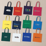 A collection of colourful tote bags in green, blue, red, purple, and black, featuring various logos.