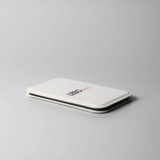 A white pocket mirror with a sleek design and a logo on the front, resting on a light grey surface.