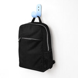 A black urban sports backpack with a front zip pocket and mesh side pocket, hanging on a blue hook.