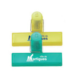 A set of three clip products in yellow and green, featuring a logo on each clip.