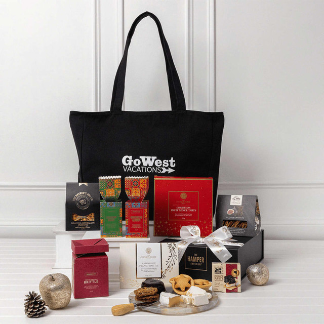 A black tote bag with assorted gourmet treats, including chocolates, cookies, and a branded box. Various colours in packaging.