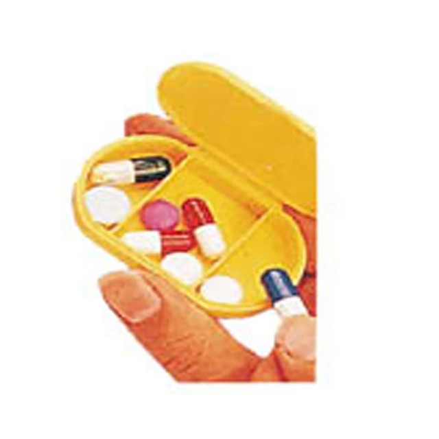 A yellow pill box held in a hand, containing various coloured capsules and tablets.