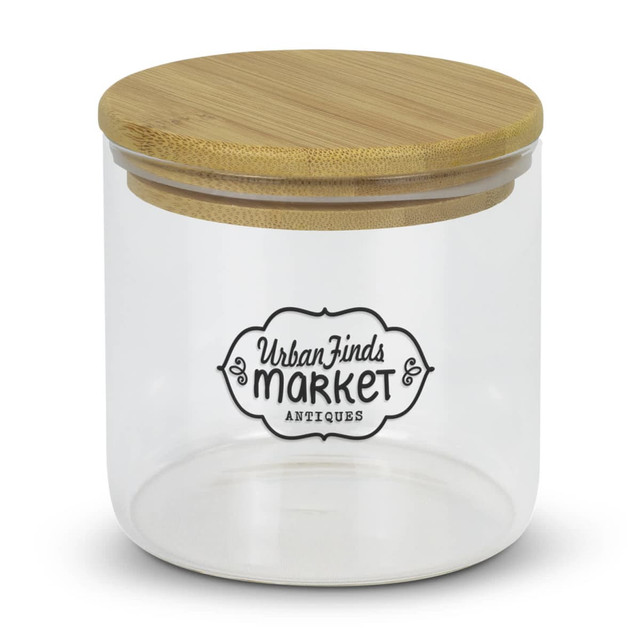 A large round glass storage canister with a bamboo lid and a decorative logo on the front.