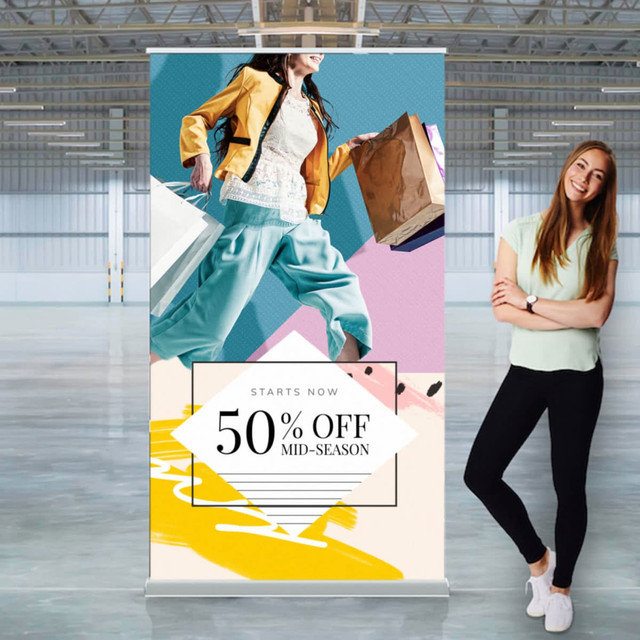 A wide pull-up banner featuring vibrant colours and a modern design, showcasing a woman carrying shopping bags.