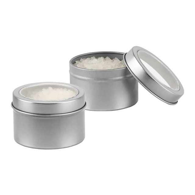 A silver tin containing bath salts, with one lid off to reveal the contents inside.