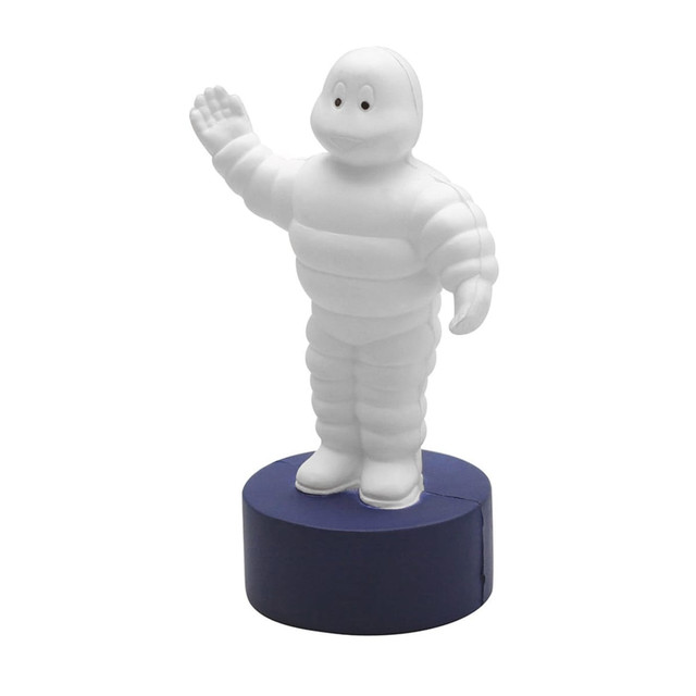 A white, waving figure resembling a tyre, mounted on a blue base, with a brand logo on the base. A white, waving figure resembling a tyre, mounted on a blue base, with a brand logo on the base.
