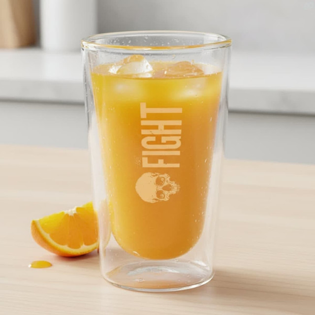 A double wall glass tumbler with a yellow drink and ice, featuring a logo, on a wooden surface.