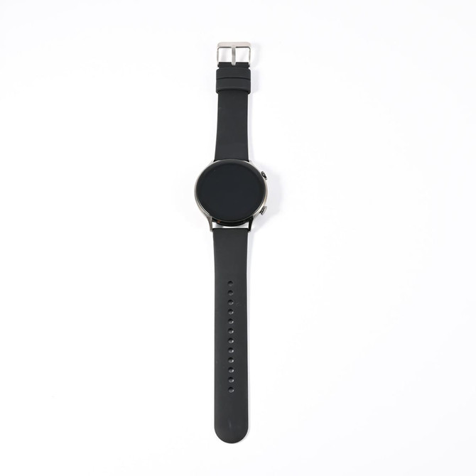 A sleek black smart watch with a round face and a smooth rubber strap, featuring a metal buckle.