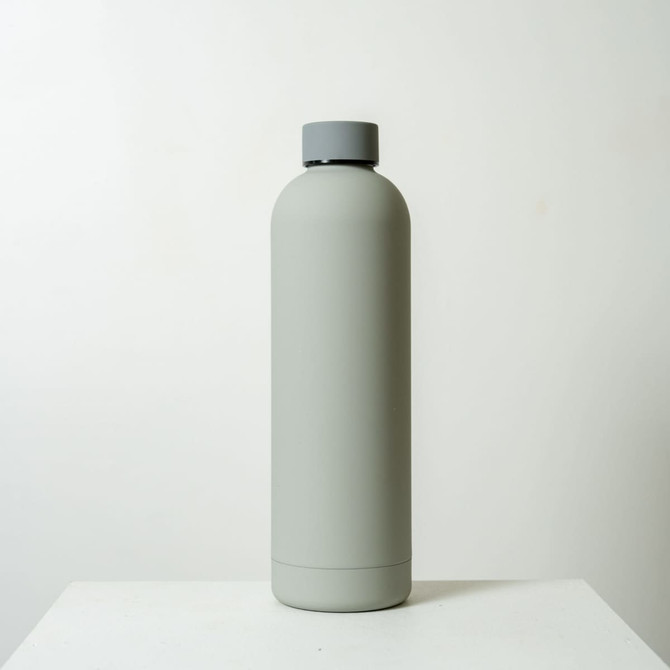 A drink bottle in matte grey with a screw-top lid and a minimalist design. It features a logo on the side.