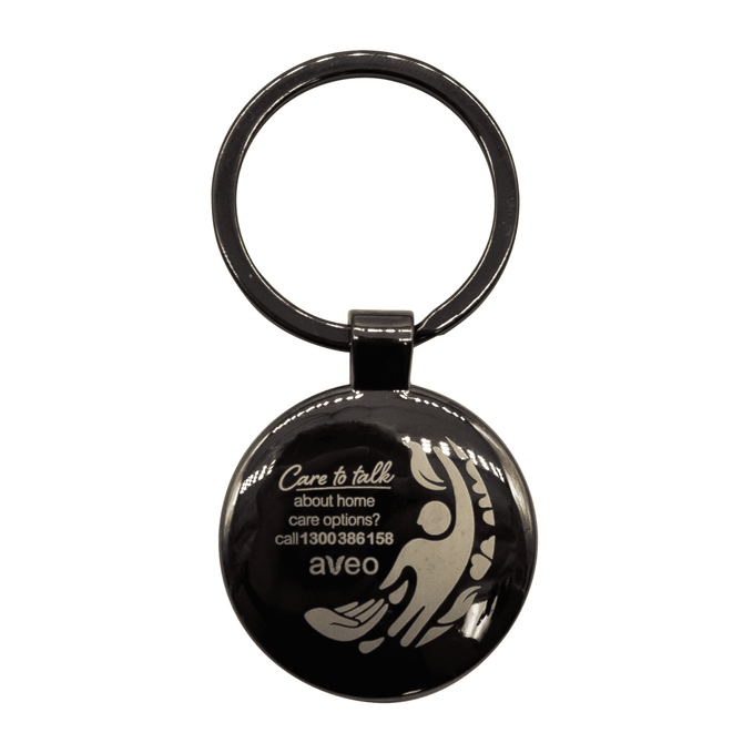 A gunmetal keychain featuring a circular shape and a design, with a branded logo.