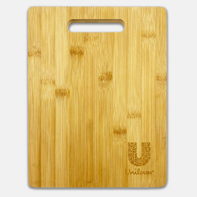 A bamboo chopping board with a handle, featuring a subtle logo in the corner. It has a natural wood finish.