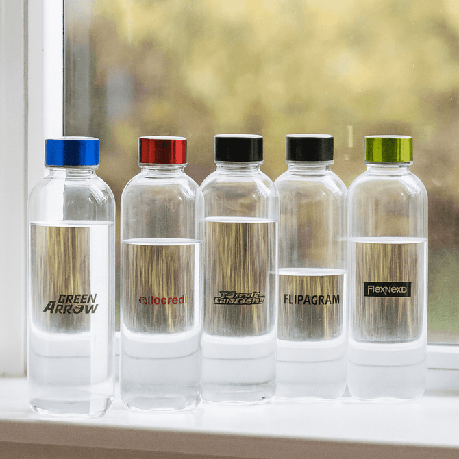 A drink bottle collection featuring five clear Tritan bottles with coloured caps in blue, red, black, and green.