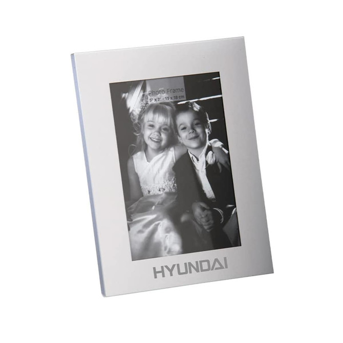 A classic aluminium photo frame in silver, featuring a black and white photo of two children. Includes a logo.